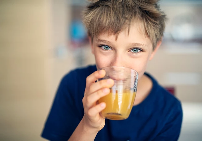 Junge trinkt Orangensaft  Vitamin-C-Tagesbedarf