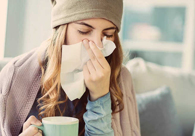 Frau putzt Nase Vitamin-D-Mangel Symptome
